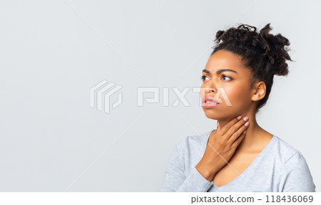 Upset afro woman having pain in her throat, touching neck, panorama with copy space Upset afro woman having pain in her throat, touching neck, panorama with copy space 118436069