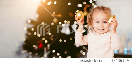 Cute little girl playing with balls for Christmas tree 118436129