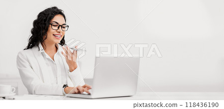 Virtual Assistant. Happy brazilian businesswoman using mobile phoneand working on laptop. Free space Virtual Assistant. Happy brazilian businesswoman using mobile phoneand working on laptop. Free space 118436190
