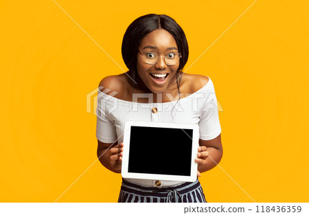 Excited African American Woman Showing Digital Tablet Blank Screen Standing Over Orange Background. Mockup, Studio Shot Excited African American Woman Showing Digital Tablet Blank Screen Standing Over Orange Background. Mockup, Studio Shot 118436359