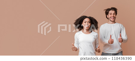 Like. Joyful Interracial Couple Jumping In The Air And Showing Thumbs Up Over Yellow Background With Empty Space 118436390