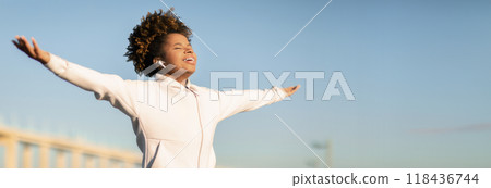 Young Black Lady Jogger Spreading Arms And Breathing Fresh Air While Training Outdoors On Sunny Day, Smiling Relaxed African American Woman In Sportswear Enjoying Outside Workout, Copy Space Young Black Lady Jogger Spreading Arms And Breathing Fresh Air While Training Outdoors On Sunny Day, Smiling Relaxed African American Woman In Sportswear Enjoying Outside Workout, Copy Space 118436744