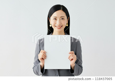 一個女人在她面前拿著一張白紙 一個女人在她面前拿著一張白紙 118437005