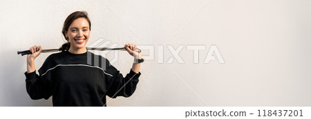 Happy muscular slim young european woman athlete in sportswear with jump rope, enjoy weight loss, fitness in city, outside on white wall background, copy space Happy muscular slim young european woman athlete in sportswear with jump rope, enjoy weight loss, fitness in city, outside on white wall background, copy space 118437201