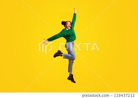 Happiness Concept. Full length portrait of excited black teen jumping over yellow studio background, copy space Happiness Concept. Full length portrait of excited black teen jumping over yellow studio background, copy space 118437212