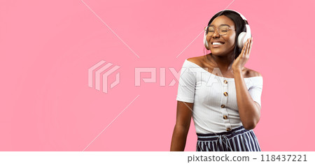 Music Lover. Happy Black Girl In Headphones Listening To Song Standing Over Beige Studio Background. Panorama, Free Space Music Lover. Happy Black Girl In Headphones Listening To Song Standing Over Beige Studio Background. Panorama, Free Space 118437221