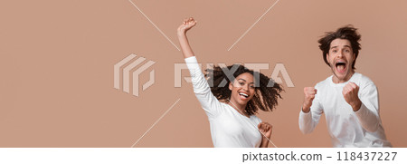 Unbelievable sales. Overjoyed multiracial couple jumping in the air and celebrating success, can't believe their luck, exclaiming with joy, panorama 118437227