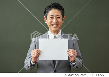 Man holding a blank piece of paper in front of him Man holding a blank piece of paper in front of him 118437272
