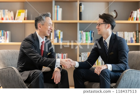 Businessmen shaking hands during business negotiations 118437513