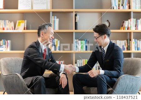Businessmen shaking hands during business negotiations 118437521