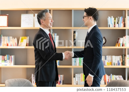 Businessmen shaking hands during business negotiations 118437553