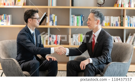 Businessmen shaking hands during business negotiations 118437557
