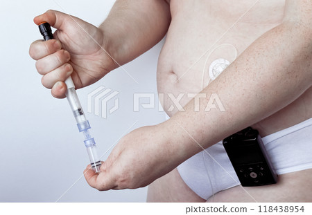 Adult with insulin pump adjusting syringe for blood sugar management Adult with insulin pump adjusting syringe for blood sugar management 118438954