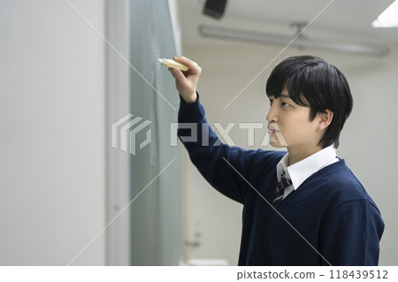 男學生用粉筆在黑板上寫字 118439512