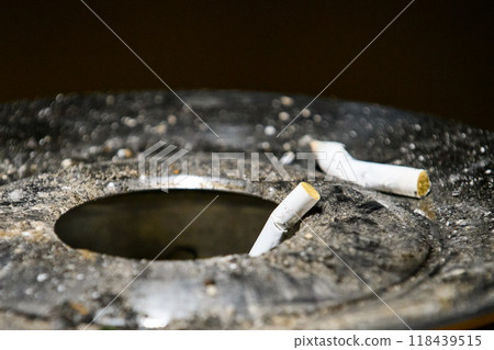 Dirty ashtray and cigarette butts Dirty ashtray and cigarette butts 118439515