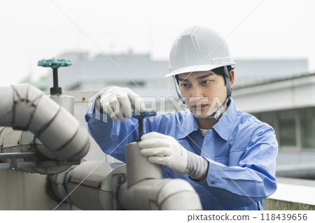 Building maintenance image: Young man inspecting water supply and drainage equipment 118439656