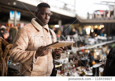 Man chooses antiques at a flea market Man chooses antiques at a flea market 118439807