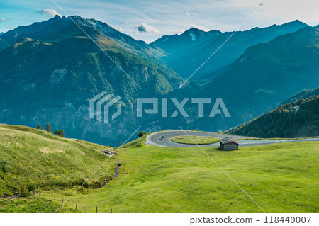 Motorbiker riding in Italian Alps during sunrise, dramatic sky. Travel and freedom, outdoor activities Motorbiker riding in Italian Alps during sunrise, dramatic sky. Travel and freedom, outdoor activities 118440007