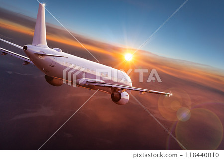 Passengers commercial airplane flying above clouds in sunset light. Concept of fast travel, holidays and business. 118440010