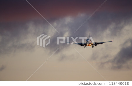 Passengers commercial airplane flying above clouds in sunset light. Concept of fast travel, holidays and business. 118440018