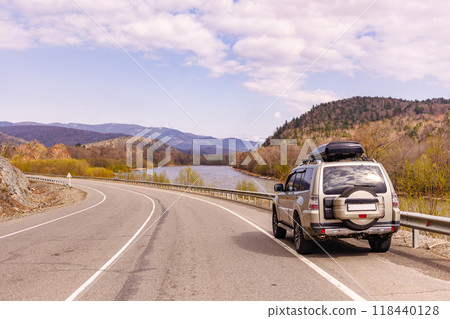 SUV on a scenic road near a river SUV on a scenic road near a river 118440128