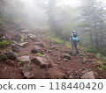Rear view of a female climber walking on the outer rim of Mount Asama, a volcano on the border between Nagano and Gunma prefectures 118440420