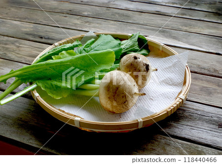 Turnips and turnip leaves with dirt on them, old table, vegetables, colander 118440466