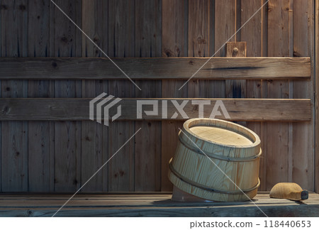 The wooden bucket and ladle sitting on wooden benches in the wooden sauna room. The wooden bucket and ladle sitting on wooden benches in the wooden sauna room. 118440653