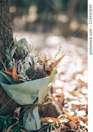 Bouquet of dried flowers placed near a tree 118441695