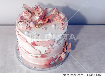Birthday cake decorated with pink sugar flowers and butterflies. 118441863