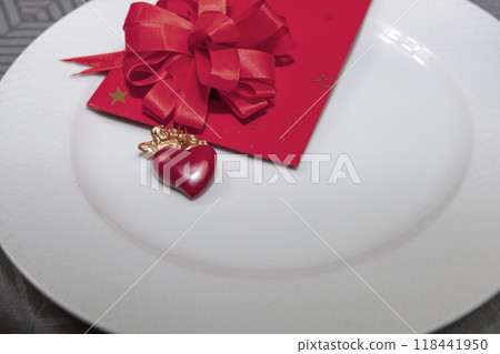 Gift with a heart and an angel in a white plate. Romantic dinner. Gift with a heart and an angel in a white plate. Romantic dinner. 118441950