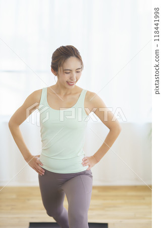A young woman taking an online yoga class at home and posing 118441998