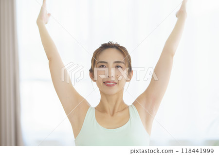 A young woman taking an online yoga class at home and posing 118441999