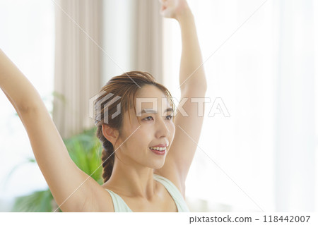 A young woman taking an online yoga class at home and posing 118442007