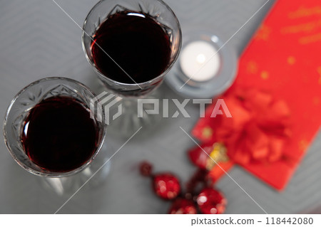 Two glasses with red wine and gift with a heart and an angel on the table. 118442080
