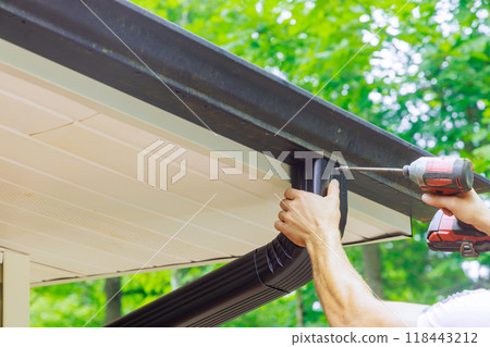Assembling installing gutter channels on roof of home Assembling installing gutter channels on roof of home 118443212