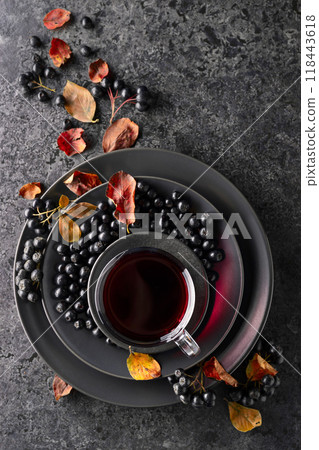 Black chokeberry drink and fresh berries on a black stone table. 118443618