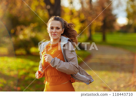 young woman in fitness clothes in park running 118443710