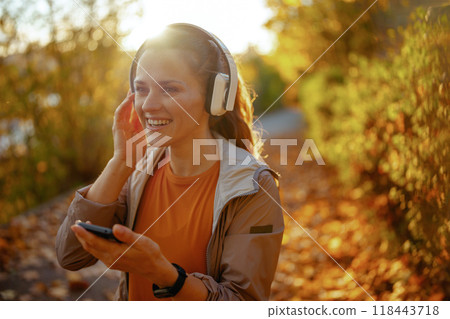 smiling trendy woman in fitness clothes in park 118443718