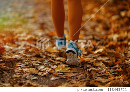Closeup on woman in fitness clothes in park walking Closeup on woman in fitness clothes in park walking 118443721