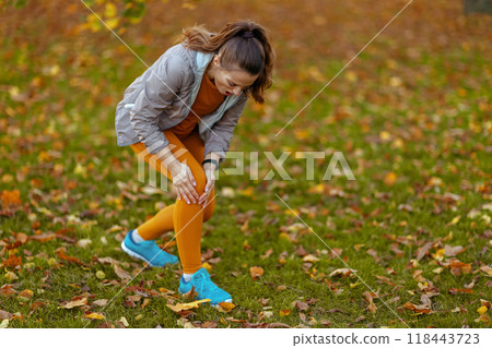 sad woman in fitness clothes in park 118443723