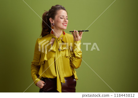 smiling fit 40 years old woman using smartphone on green smiling fit 40 years old woman using smartphone on green 118443812