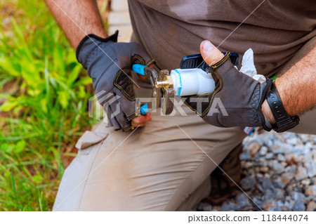 An plumber seals pvc plastic faucets together before connecting them to water supply system 118444074