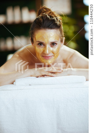 happy modern woman in massage cabinet laying on massage table 118444250