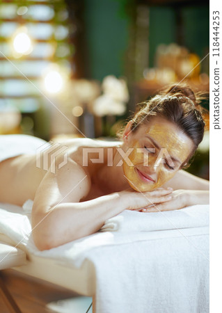 relaxed modern woman in spa salon laying on massage table 118444253