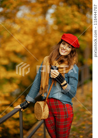 Portrait of happy stylish woman in jeans shirt and red hat Portrait of happy stylish woman in jeans shirt and red hat 118444707