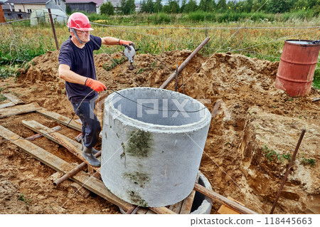 Rigger used rollers and winch to slide one concrete ring onto another during installation of septic tank 118445663