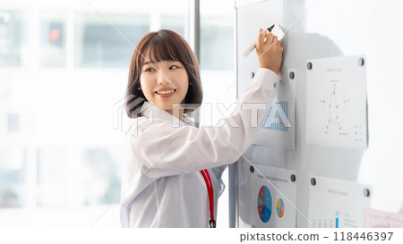 Young businesswoman giving a presentation using a whiteboard Young businesswoman giving a presentation using a whiteboard 118446397