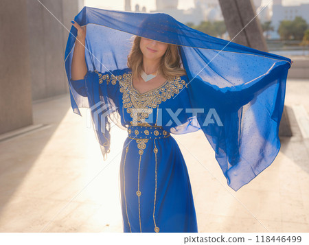 Travel to the United Arab Emirates, Abu Dhabi. Woman in blue Arabic dress near Sheikh Zayed Great white mosque. famous Abu Dhabi sightseeing. Travel to the United Arab Emirates, Abu Dhabi. Woman in blue Arabic dress near Sheikh Zayed Great white mosque. famous Abu Dhabi sightseeing. 118446499