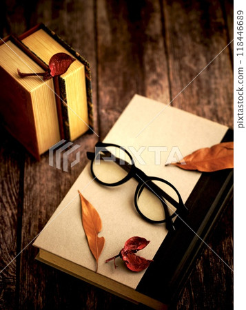 木桌上的書、眼鏡和枯葉 118446689